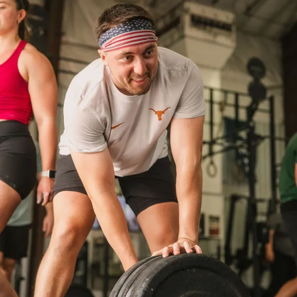 Private trainer coaching a member through a lift